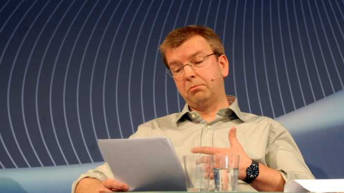 OHRENBÄR-Autor Hubert Schirneck liest aus seinen Geschichten, blauer ARD-Hintergrund (Quelle: rbb/OHRENBÄR/Birgit Patzelt)