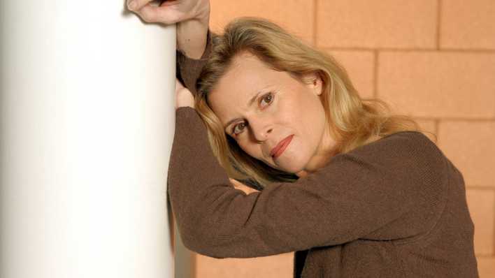 Porträt der Schauspielerin Leslie Malton, lehnt an einem weißen Pfeiler und blickt in die Kamera (Quelle: imago images/Hogreve)