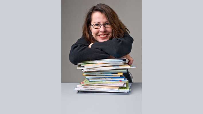 Porträt der Autorin Annette Neubauer, stützt sich freudig auf einen Stapel Bücher (Quelle: privat) Porträt der Autorin Annette Neubauer, stützt sich freudig auf einen Stapel Bücher (Quelle: privat)