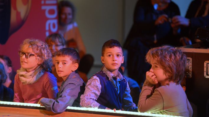 Kinder am Bühnenrand verfolgen das Geschehen auf der Bühne (Quelle: rbb/Thomas Ernst)