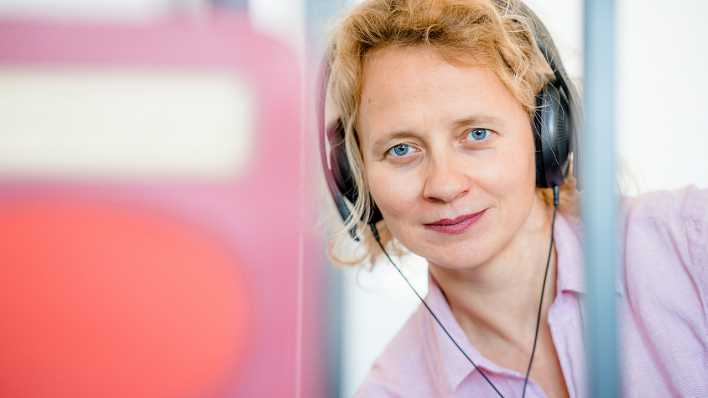 OHRENBÄR-Redakteurin Birgit Patzelt mit Kopfhörern, vor dem großen OHRENBÄR-Radio (Quelle: rbb/Gundula Krause)