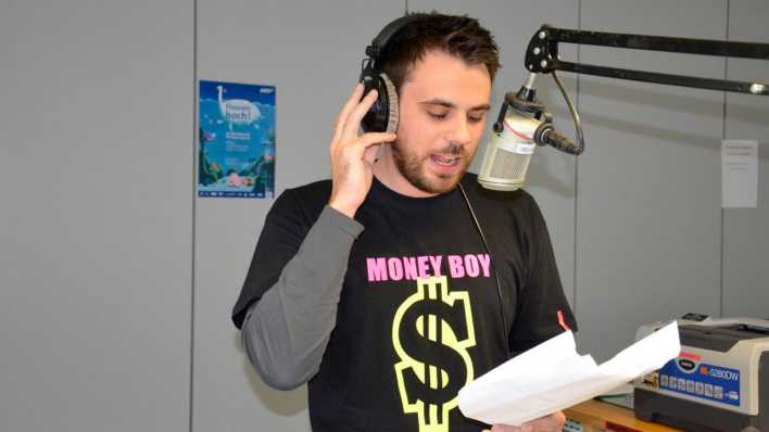 Sänger Alex Zander im Studio, singt ins Mikrofon, im Hintergrund ein Plakat der ARD-Radionacht für Kinder © ARD