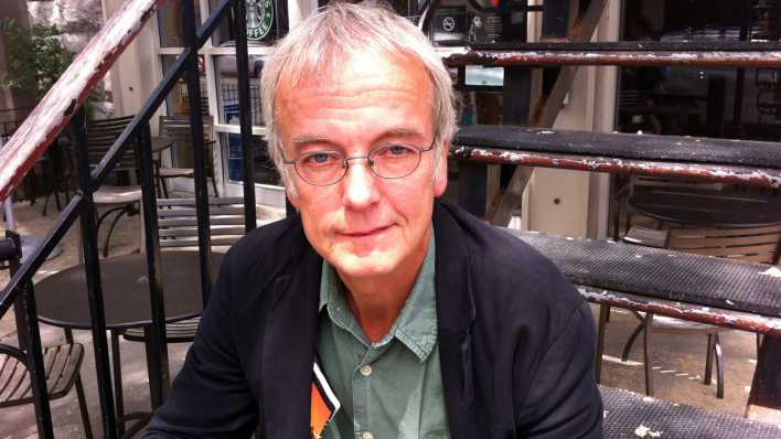 Porträt des Autors Jens Sparschuh, sitzend auf einer Außentreppe (Quelle: privat)