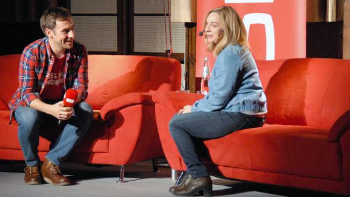 rbb-Moderator Marc Langebeck und Autorin Jeanette Wagner auf der roten Couch, er interviewt sie (Quelle: rbb/OHRENBÄR/Birgit Patzelt)