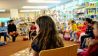 Kinder und Erwachsene in einem Stuhlkreis, im Hintergrund Bücherregale (Quelle: rbb/OHRENBÄR/Lisa Thieler)