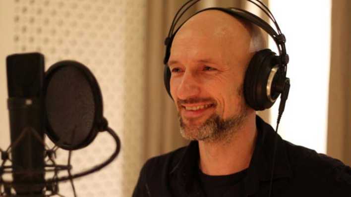 Porträt des Schauspielers Tilo Werner, mit Kopfhörer und vor einem Mikrofon (Quelle: privat)