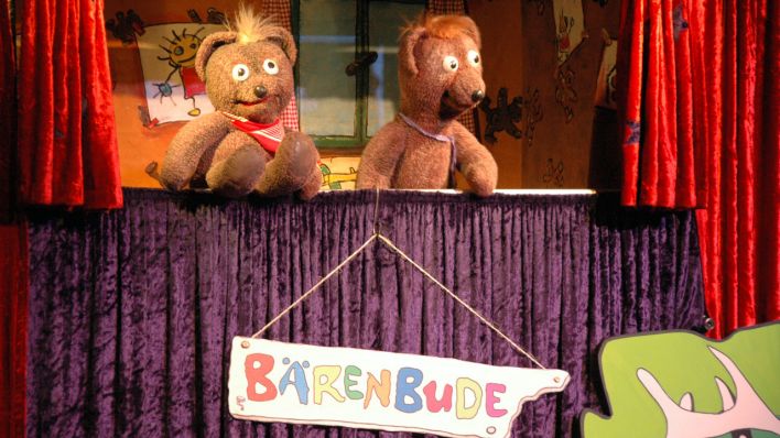 Die Puppen Johannes und Stachel auf der Bühne, unter ihnen das Schild "Bärenbude" (Quelle: rbb)